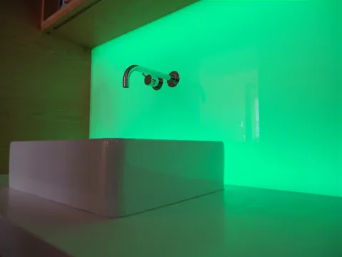 RGB Flächenlicht Grün mit Glasfront in einem Münchner Loft-Appartement, Armaturen gehen durch Glas und Lichtfläche